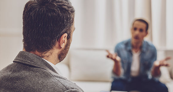 a person talking with a doctor sitting opposite of one another