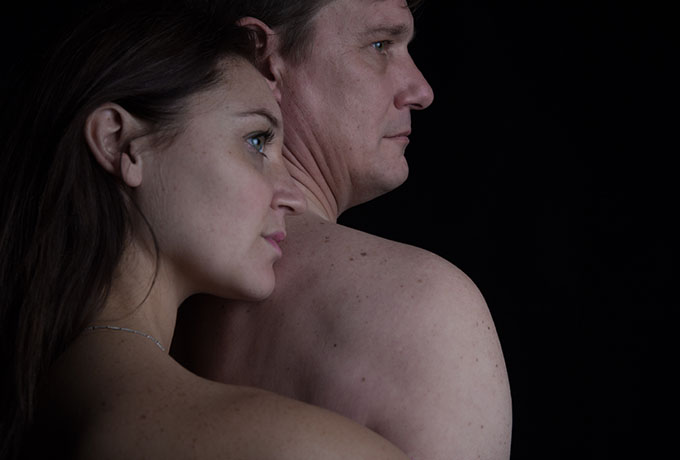 a man and a woman standing together in a dark room