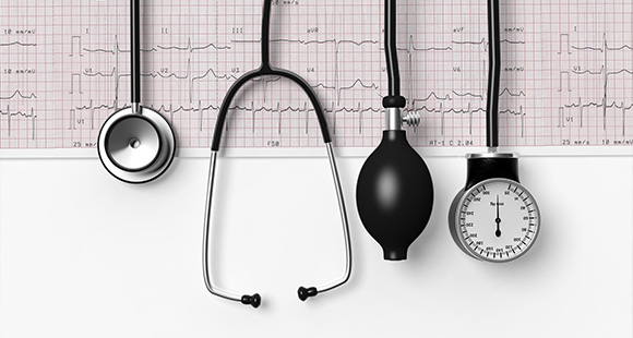 four cardiology tools lined up on top of a cardiograph