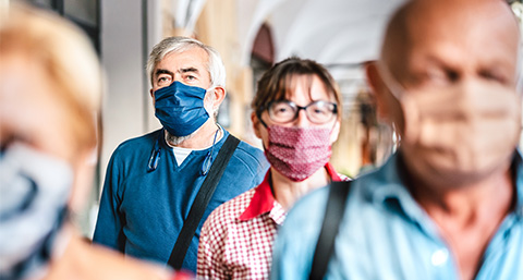 a group of people wearing face masks walking down a street