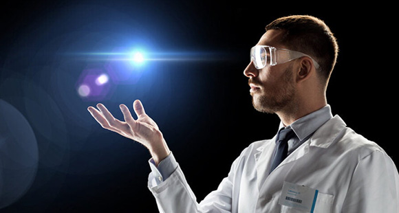 a scientist wearing goggles holding a floating ball of light over his hand