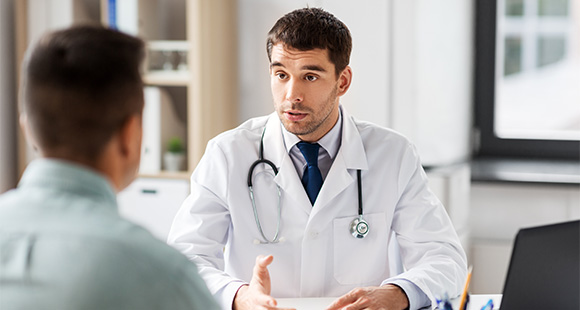 a male doctor talking with a man in his office